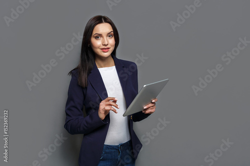 Woman with tablet on gray background