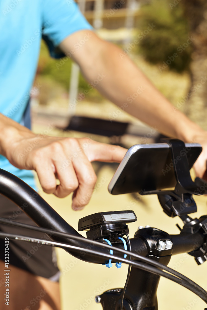 young man using a smartphone riding a bicycle young man using a smartphone riding a bicycle