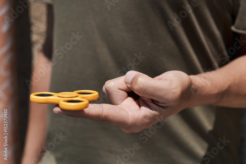 young man playing with a fidget spinner photo