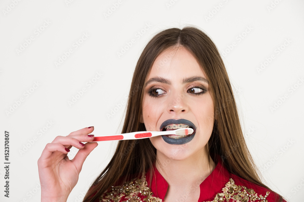 girl with teeth braces and brush, has fashionable makeup girl with teeth braces and brush, has fashionable makeup