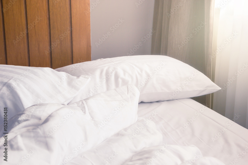 white pillow and blanket with wrinkle messy on bed in bedroom with lighting upper left side, from sleeping in a long night winter. white pillow and blanket with wrinkle messy on bed in bedroom with lighting upper left side, from sleeping in a long night winter.