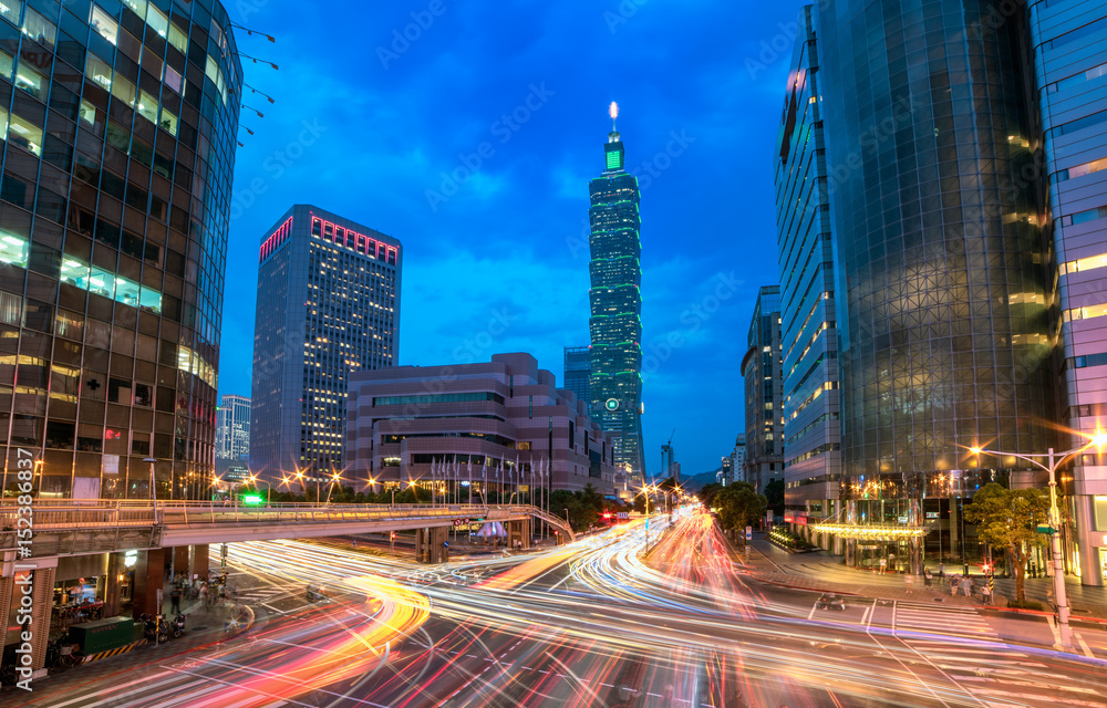 Fototapeta premium Downtown Taipei City with busy traffic trails at rush hour ~ Beautiful night scenery of Taipei 101 Tower & World Trade Center buildings in XinYi Financial District