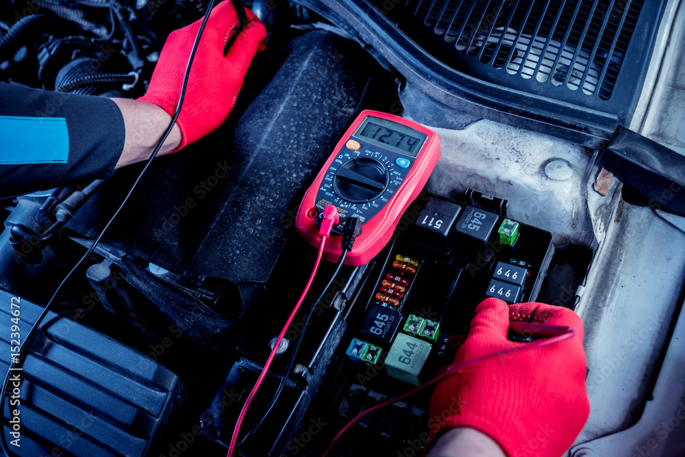Auto mechanic uses a voltmeter to check the voltage level. Auto mechanic uses a voltmeter to check the voltage level.