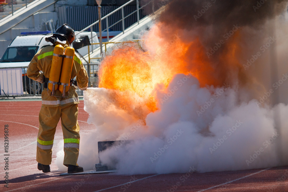 Firefighter in equipment extinguishes fire with a fire extinguisher