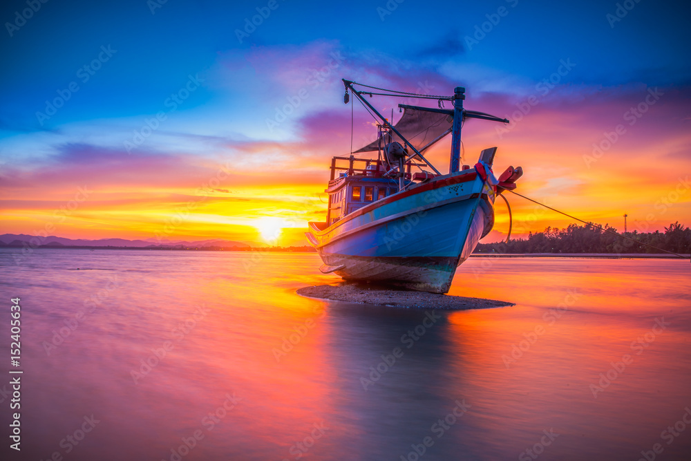 Fishing boat in tropical beach with beautiful sunset time. Stock Photo