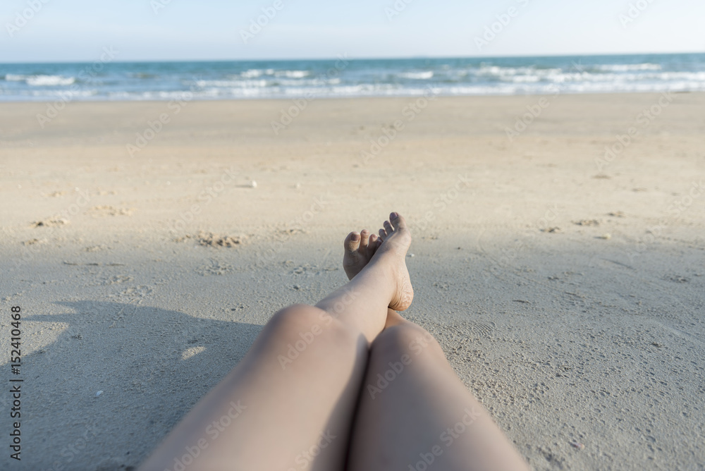 Foto de Closeup barefoot woman legs at the beach,summer time.happy woman  lying on the beach. do Stock | Adobe Stock