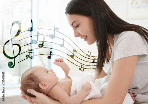 Happy mother with cute little baby at home