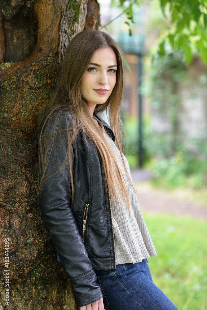 Young attractive woman hiding from the rain under a tree. Girl in rainy day, soft focus. Beautiful female face. Young attractive woman hiding from the rain under a tree. Girl in rainy day, soft focus. Beautiful female face.