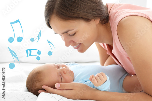 Tableau sur toile Portrait of young mother and her sleeping baby, close up view