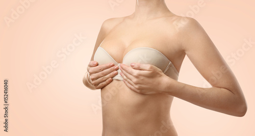 Foto Young woman in beige bra on white background
