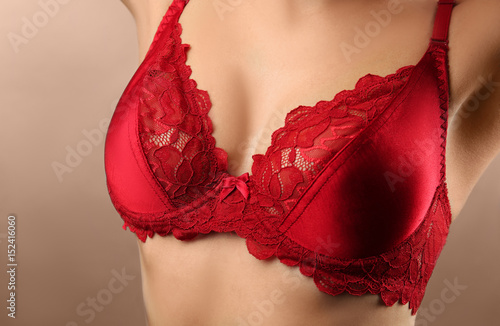 Young woman in red bra on grey background