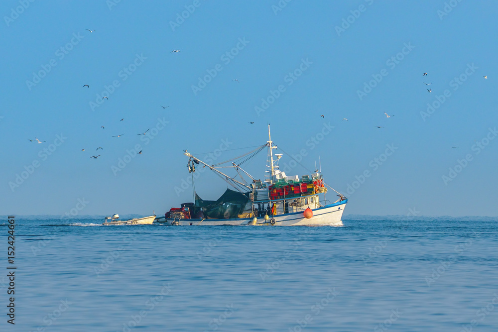 Ein Fischerboot ist auf dem Heimweg