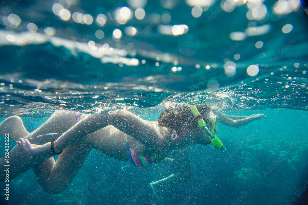 girl in the mask under the water, engage in snorkeling