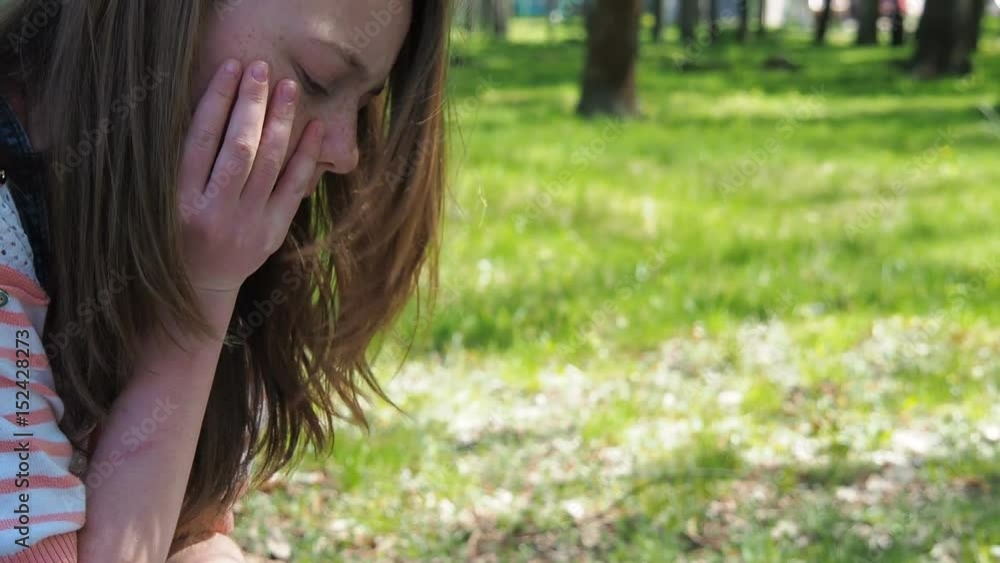 A girl with freckles is reading in the park. Hands in the scars of a teenage girl. Bracelets on hands. Slow motion. A girl with freckles is reading in the park. Hands in the scars of a teenage girl. Bracelets on hands. Slow motion.