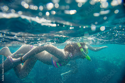 girl in the mask under the water  engage in snorkeling