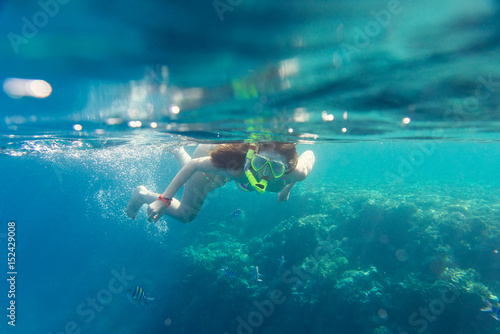 girl in the mask under the water  engage in snorkeling
