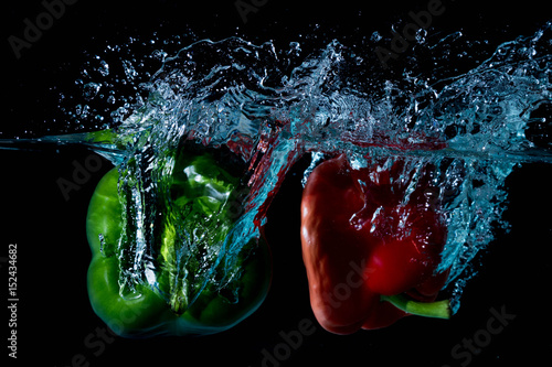 Green & Red Bell Sweet Peppers Droped Into Water