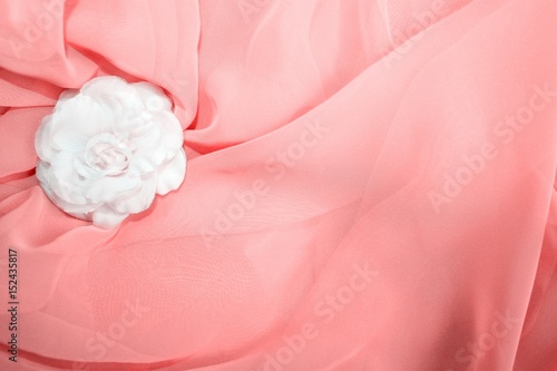 White textile rose and light red textile background