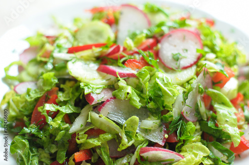 Spring vegan salad with tomato, cucumbers, radish and chinese cabbage
