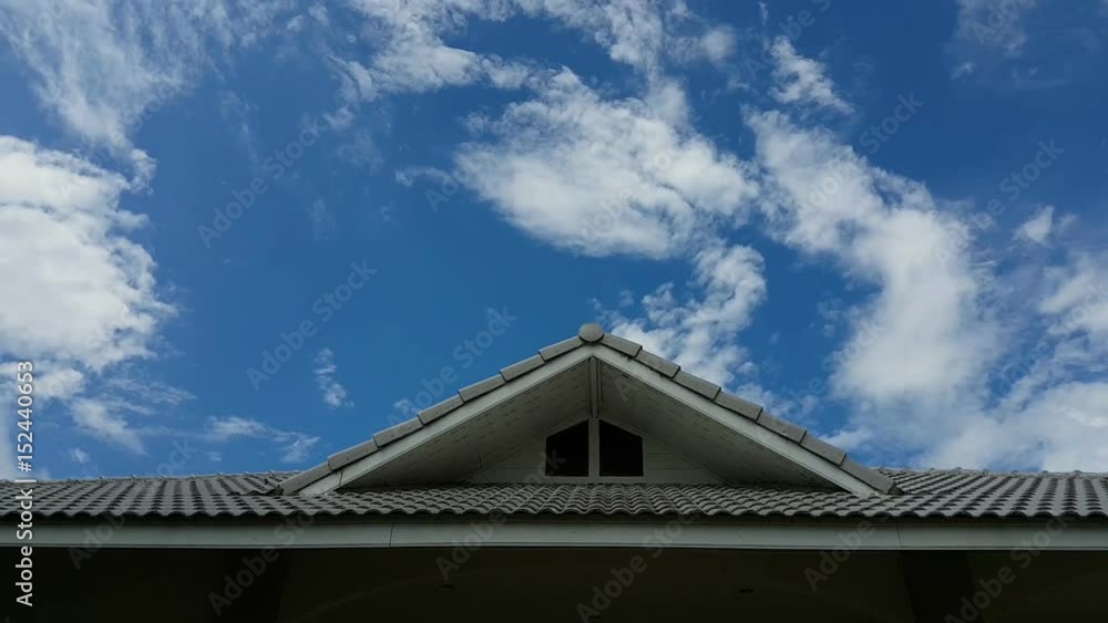 Time lapse of clouds in the blue sky moving fast over the gable house Time lapse of clouds in the blue sky moving fast over the gable house