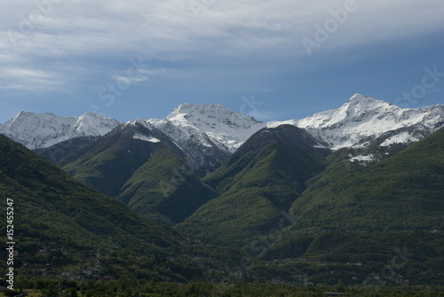 Landscape of mountains of a strong spring green, with snow-covered peaks after a strong thunderstorm of mountain, alps, italy