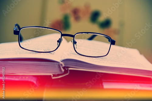 Glasses lie on the pages of an old open book