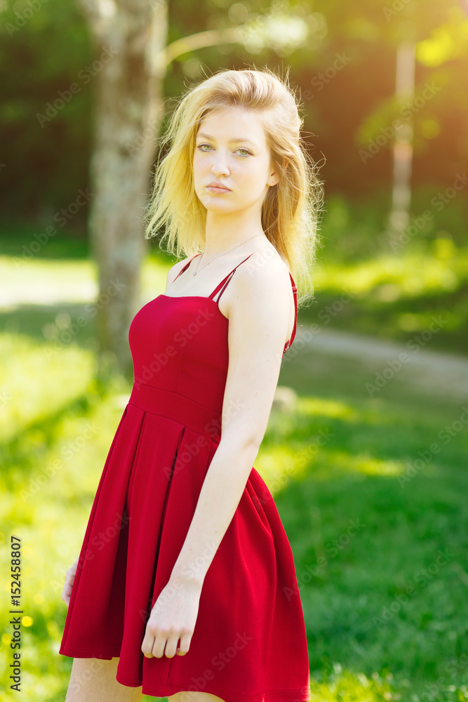 Young blonde woman posing in the park. Teenager fashion lifestyle. Young blonde woman posing in the park. Teenager fashion lifestyle.