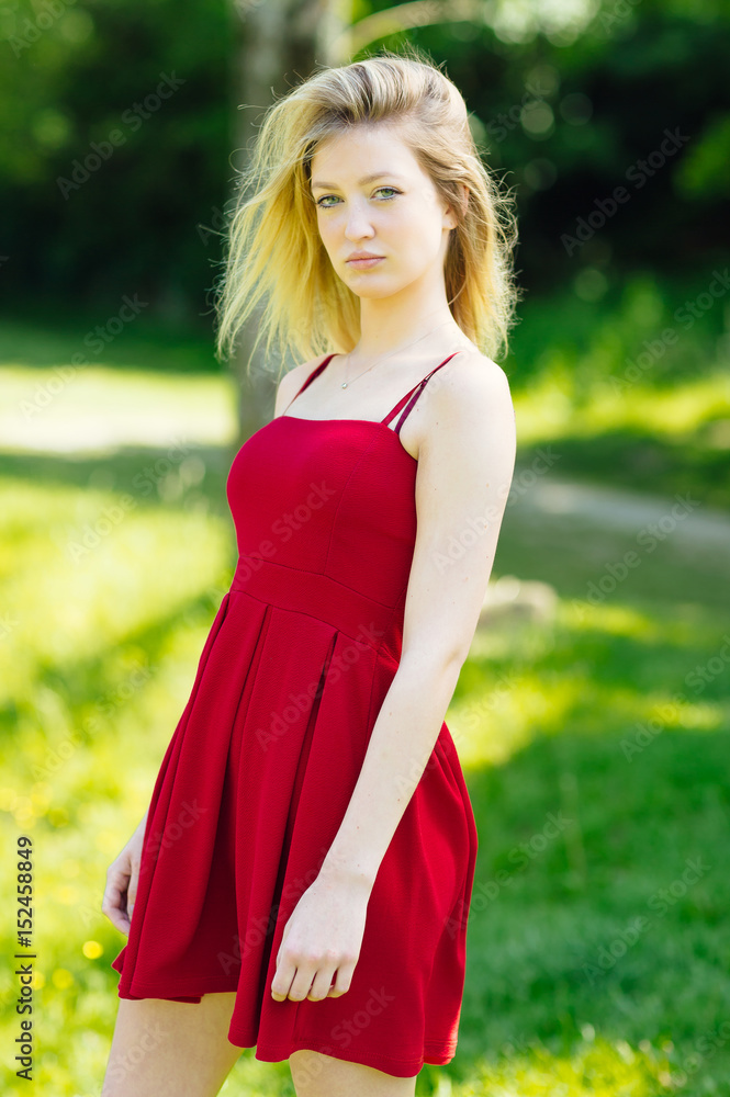 Young blonde woman posing in the park. Teenager fashion lifestyle. Young blonde woman posing in the park. Teenager fashion lifestyle.