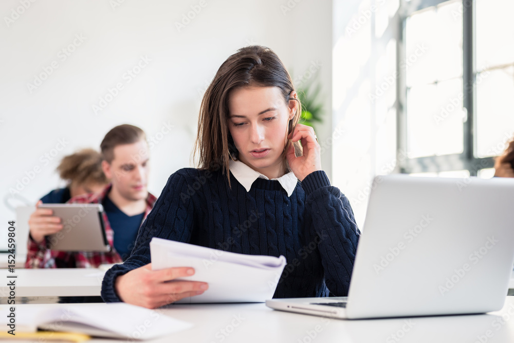 Portrait of a young hard-working student writing during class in a modern college or university Portrait of a young hard-working student writing during class in a modern college or university