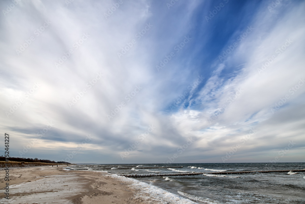 Idyllic panoramic view over stormy German Baltic Sea at Zingst in the winter with beautiful light and clouds.