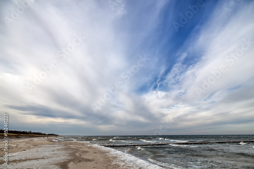 Idyllic panoramic view over stormy German Baltic Sea at Zingst in the winter with beautiful light and clouds.