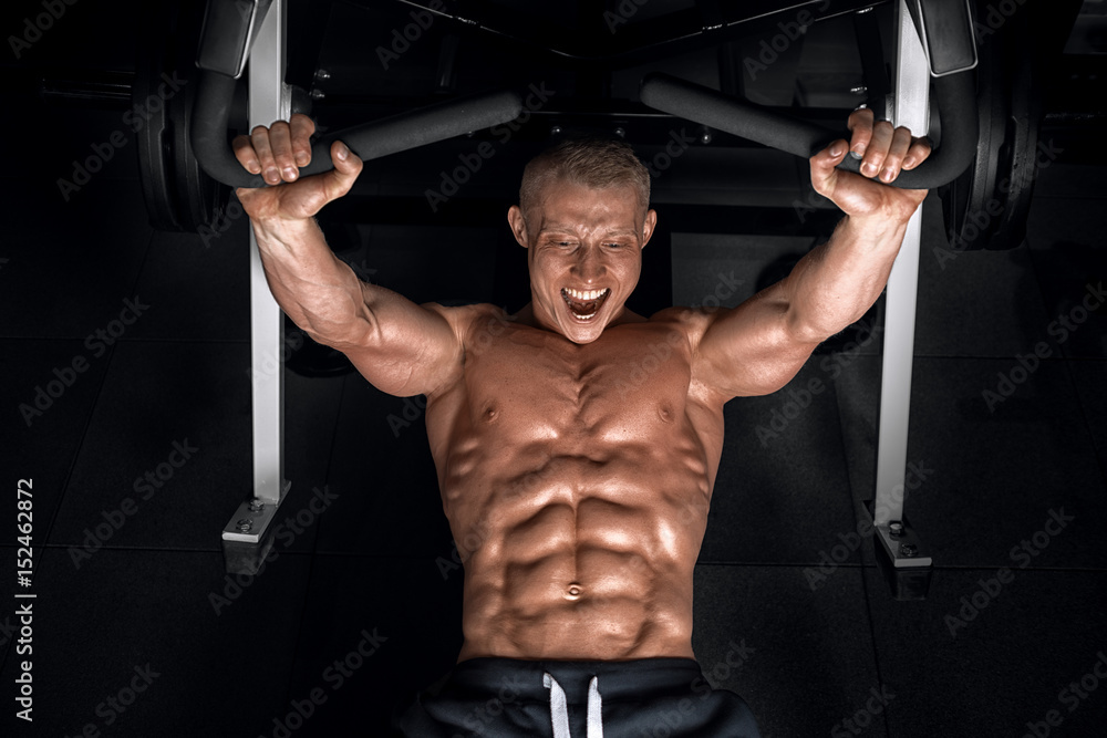 Young handsome guy doing exercises in the gym Young handsome guy doing exercises in the gym