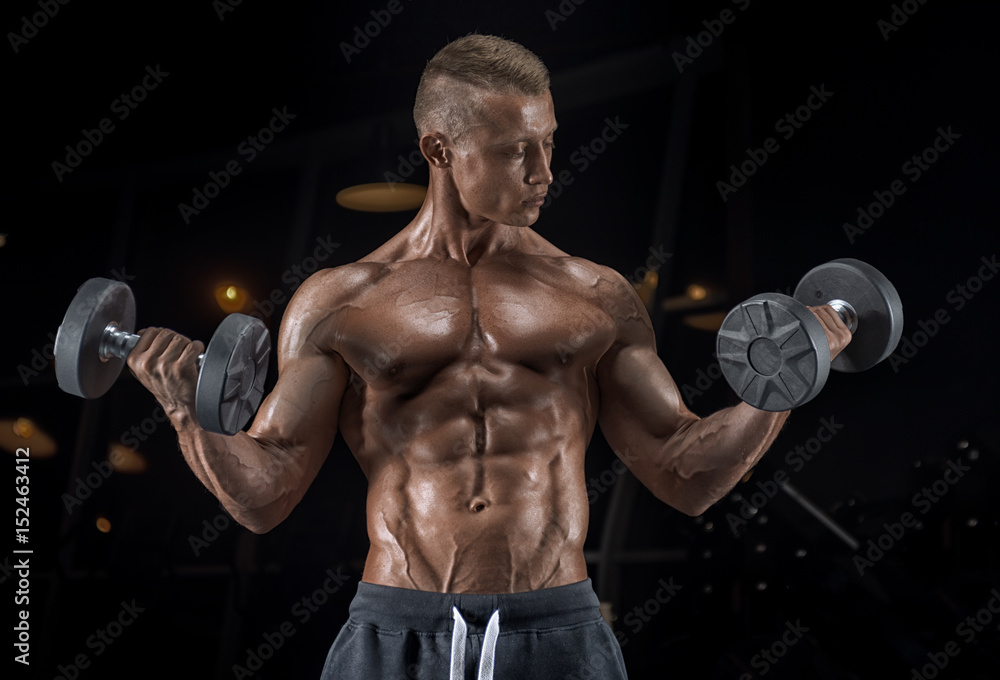 Young handsome guy doing exercises in the gym Young handsome guy doing exercises in the gym