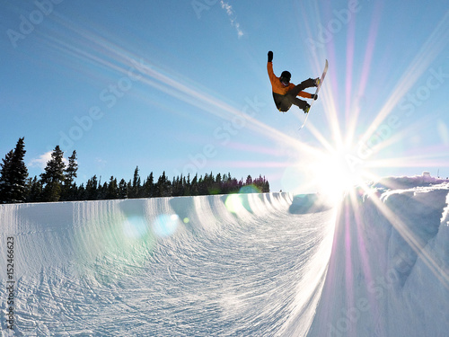 Snowboarder Getting some Air in Full Pipe 