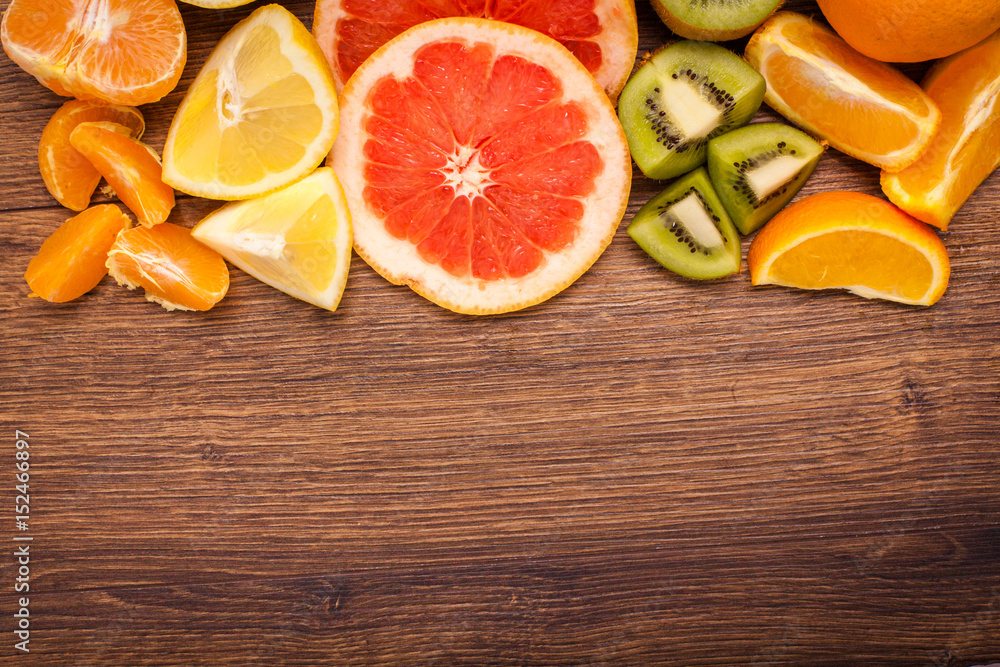 lemon, orange, kiwi, grapefruit, mandarin on a wooden surface. arrangement of sliced fruit. Top view with copy space for text lemon, orange, kiwi, grapefruit, mandarin on a wooden surface. arrangement of sliced fruit. Top view with copy space for text
