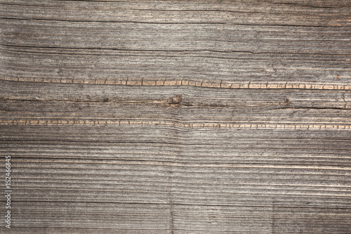 The relief texture of the surface of the old wooden board with poor processing, the expressive direction of the wood fibers and the cutoff point of the knot