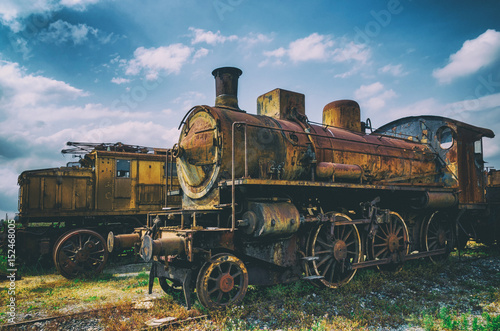 Vintage looking photo of two rusty old talian steam and electric locomotives photo