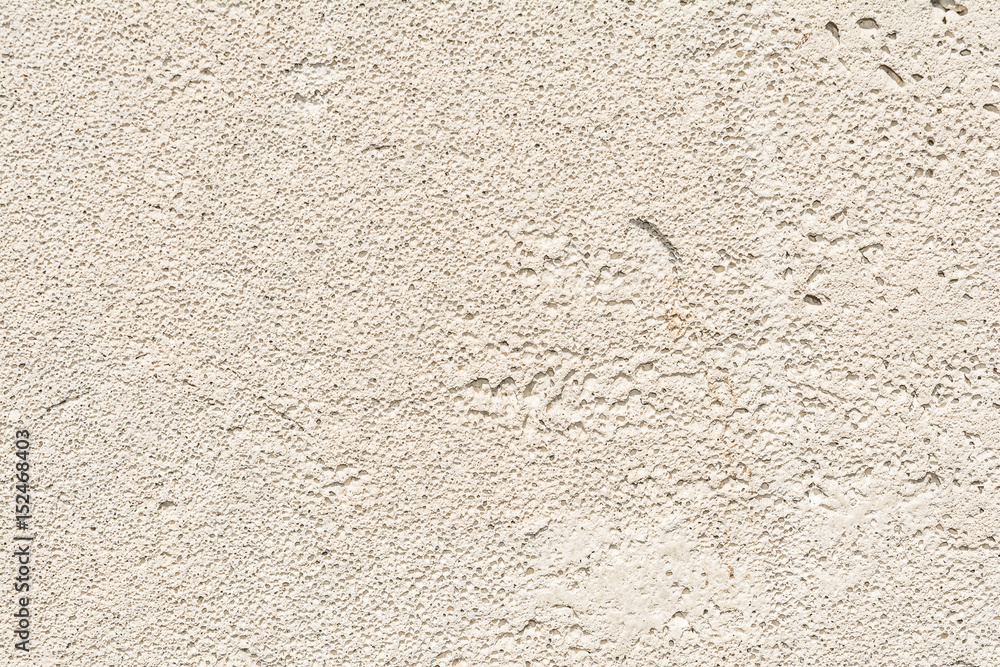 Fototapeta premium Gray texture of the porous surface of the concrete wall of the building with minor damages