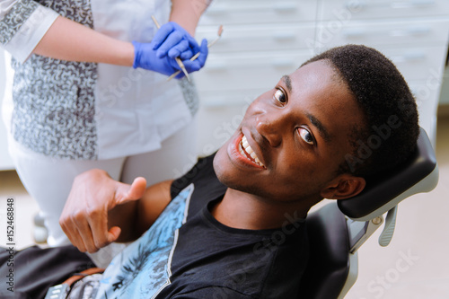 African patient in dentistry smiling in dental chair