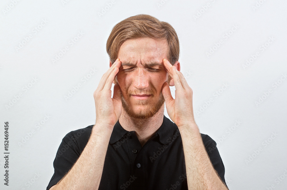Headache. Unpleasant Young Adult Male in Black T-Shirt in Pain Touches His Head, Eyes Closed Headache. Unpleasant Young Adult Male in Black T-Shirt in Pain Touches His Head, Eyes Closed