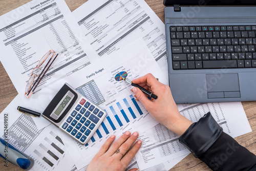 Fotografi Business woman account annual budget with laptop, pen and graph.