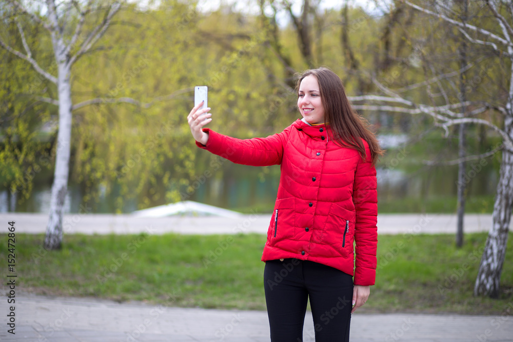 A young girl photographed themselves on the phone selfie in spring day A young girl photographed themselves on the phone selfie in spring day