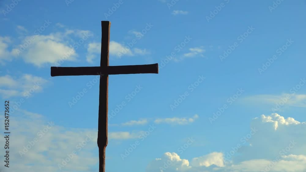 timelapse of iron Catholic Cross isolated on background of moving clouds timelapse of iron Catholic Cross isolated on background of moving clouds