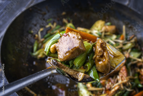 Traditional stir fried Chicken Gung Bao with Vegetable as close-up on Shovel photo