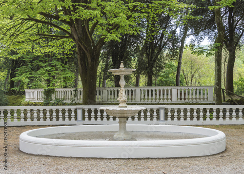 900's architecture, white stone fountain on a park, without water