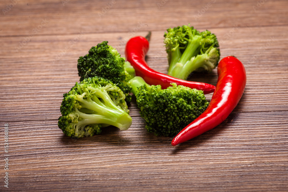 green broccoli, red chili on a wooden surface