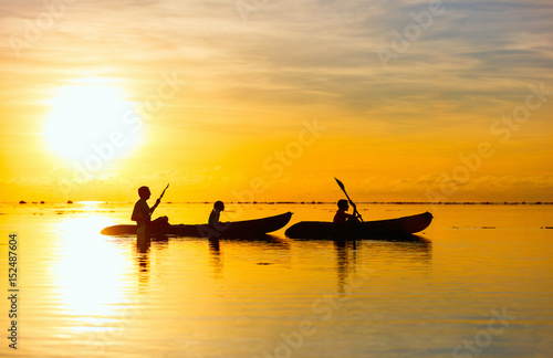 Family kayaking at sunset