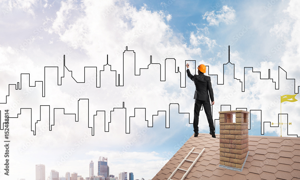 Man architect draw silhouette of modern city on blue sky. Mixed media