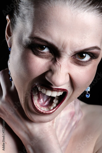 Canvas Print luxury woman shouts smothers herself looking at camera on black background