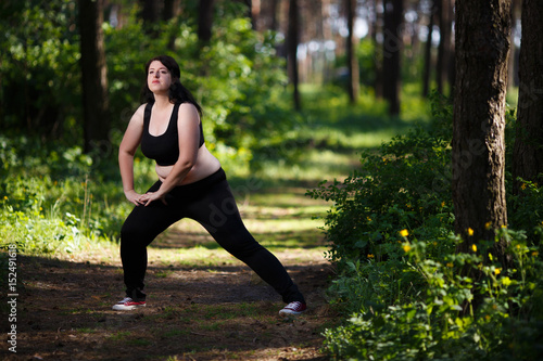 Young overweight woman working out in the park